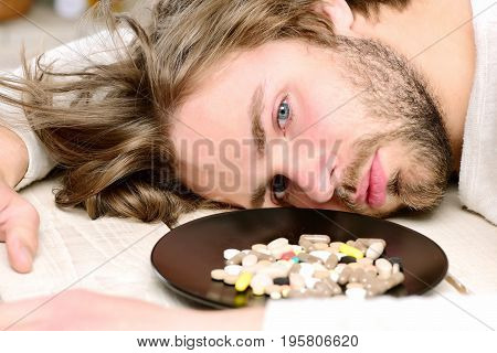 Pills On Plate Near Motionless Guy With Beard