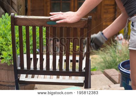 Painting and applying protective varnish on a wooden garden chair