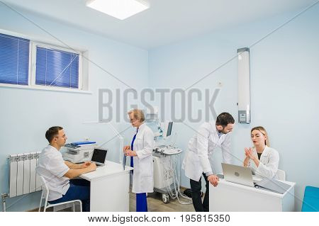 Group Of Doctors Involved In Serious Discussion With Medical Records.