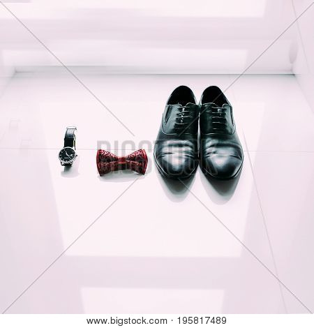 Groom's shoes, bow tie and watch on light background. Preparation for wedding concept.