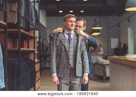 Mature tailor and customer in atelier