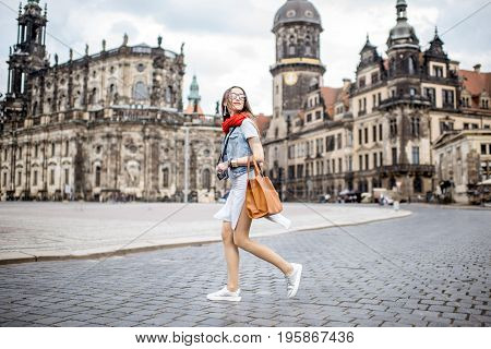 Young woman with photocamera walking on the Theaterplatz in Dresden, Germany
