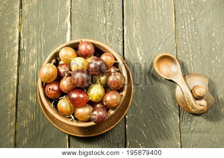 Many Berries In The Plate. Gooseberry. Top View. Dark Background. Decorative Photo. Warm Mood.