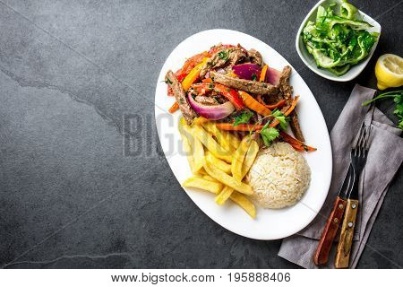 Peruvian Dish Lomo Saltado - Beef Tenderloin With Purple Onion, Yellow Chili, Tomatoes Served On Whi