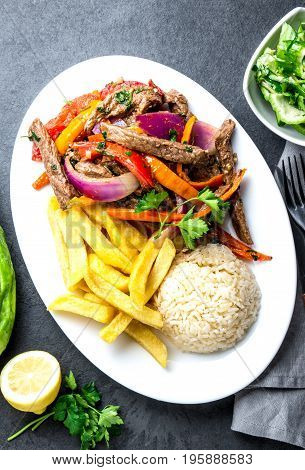 Peruvian Dish Lomo Saltado - Beef Tenderloin With Purple Onion, Yellow Chili, Tomatoes Served On Whi