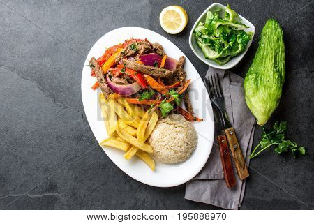 Peruvian Dish Lomo Saltado - Beef Tenderloin With Purple Onion, Yellow Chili, Tomatoes Served On Whi