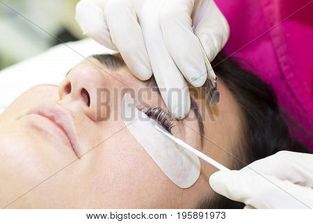 Woman on the procedure for eyelash extensions, eyelashes lamination