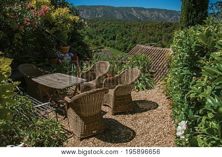 View of small garden with mountains and sunny blue sky in the background, at the village of Ménerbes. Located in the Vaucluse department, Provence-Alpes-Côte d'Azur region, southeastern France