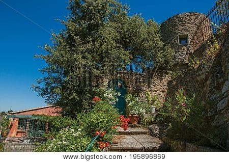View of staircase and gate with flowers and sunny blue sky in the background, at the village of Ménerbes. Located in the Vaucluse department, Provence-Alpes-Côte d'Azur region, southeastern France