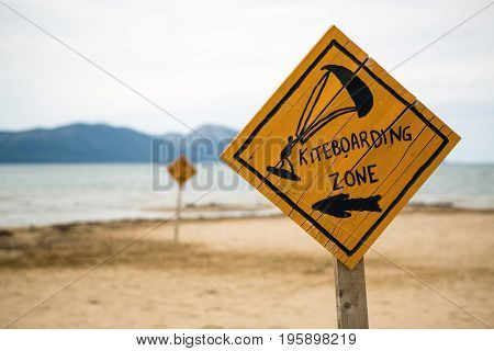 Kiteboarding sign wooden kitesurfing signpost on a beach at adriatic sea in Croatia. Inspiring kitesurfer silhouette sport and recreation concept.