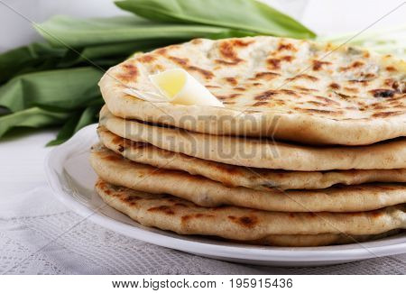 Khychiny - traditional caucasian flatbread filled with сheese and herbs. Flat bread stuffed with feta and wild garlic.
