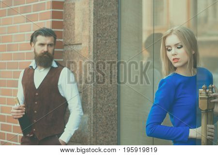 Hipster With Bottle Of Wine Looking At Woman Opening Door