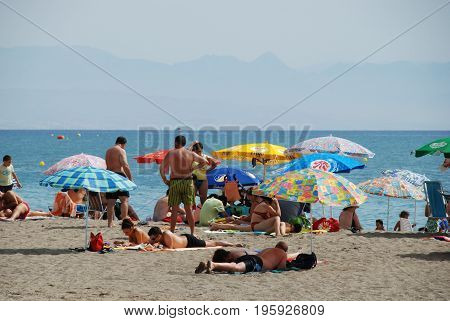 TORREMOLINOS, SPAIN - SEPTEMBER 3, 2008 - Holidaymakers relaxing on the beach Torremolinos Malaga Province Andalusia Spain Western Europe, September 3, 2008.