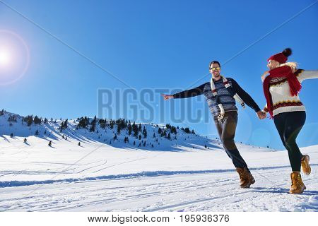 Cheerful young couple having fun in winter park.