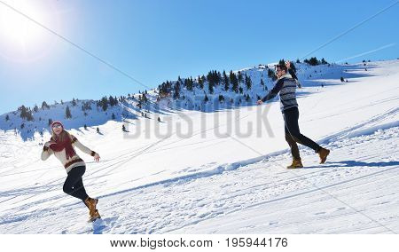 Cheerful young couple having fun in winter park.