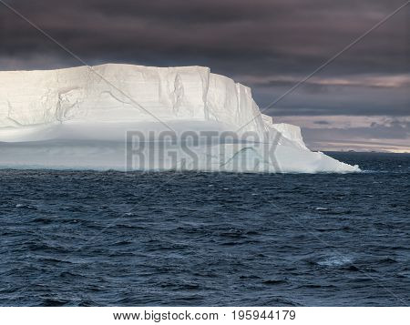 Huge Tabular Iceberg floating in Bransfield Strait at sunset, Antarctica