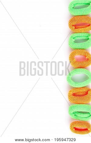 Green and orange soft hair bands are lined with a line on a white background