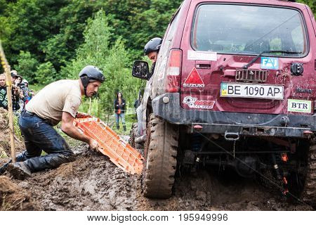 LUBOTIN UKRAINE - JULY 23 2016: RFC Ukraine Wild Boar Challenge 2016. Team using recovery sand tracks to overcome a hard pit.