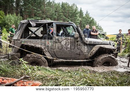 LUBOTIN UKRAINE - JULY 23 2016: RFC Ukraine Wild Boar Challenge 2016. The participant on Jeep passes a deep muddy pit.