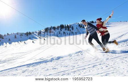 Cheerful young couple having fun in winter park.
