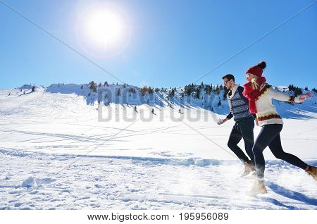 Cheerful young couple having fun in winter park.
