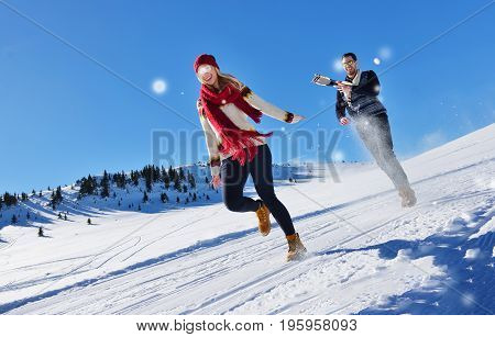 Cheerful young couple having fun in winter park.