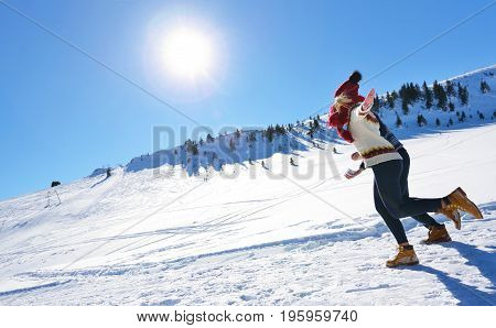 Cheerful young couple having fun in winter park.