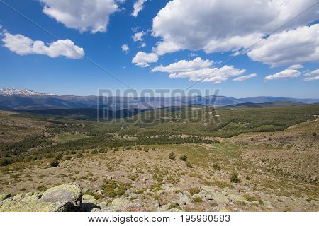 landscape green countryside trees blue sky and clouds in Lozoya Valley and Guadarrama Natural Park from Morcuera mountains in Madrid Spain Europe