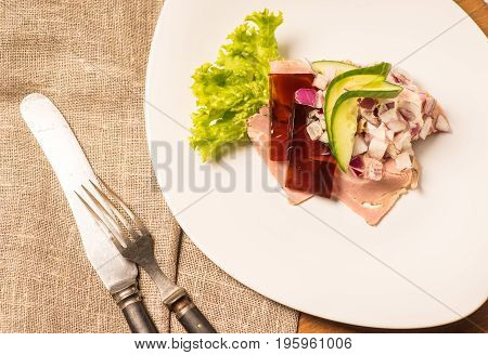 Danish specialties and national dishes high-quality open sandwich. Sandwich with pork roll sausage rullepoelse jelly and raw red onions served on a plate ready for eating