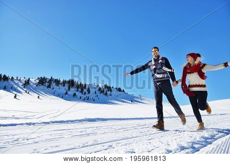 Cheerful young couple having fun in winter park.
