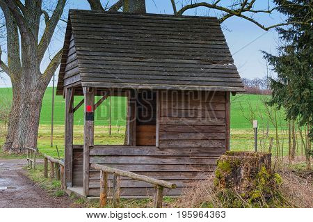 Old wooden hut to shelter from wind rain or snow at a pond near the town of Heiligenhaus in Germany.