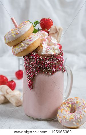 Pink strawberry freakshake milkshake with sweets donut and marshmallow