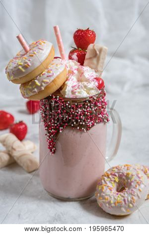 Pink strawberry freakshake milkshake with sweets donut and marshmallow