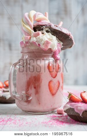 Pink strawberry freakshake milkshake with sweets donut and marshmallow