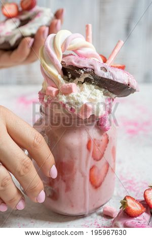 Pink strawberry freakshake milkshake with sweets donut and marshmallow