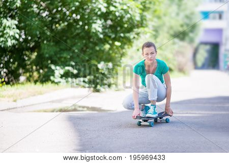 Beautiful girl rides on a highway on Longboard scenic street. Solar toning. Close-up portrait. Healthy lifestyle.