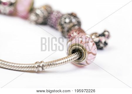 Silver charm bracelet with pink beads isolated on white background