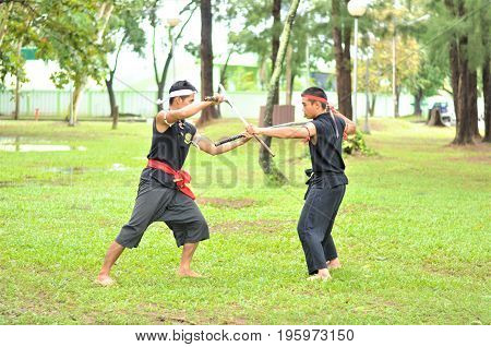 PUKED,THAILAND - AUGUST 28: Master trick of ancient fighter on August 28, 2011 in Puked Thailand.
 Master show how to trick of fight with swords.