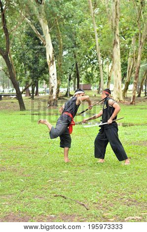 PUKED,THAILAND - AUGUST 28: Master trick of ancient fighter on August 28, 2011 in Puked Thailand.
 Master show how to trick of fight with swords.