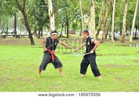 PUKED,THAILAND - AUGUST 28: Master trick of ancient fighter on August 28, 2011 in Puked Thailand.
 Master show how to trick of fight with swords.