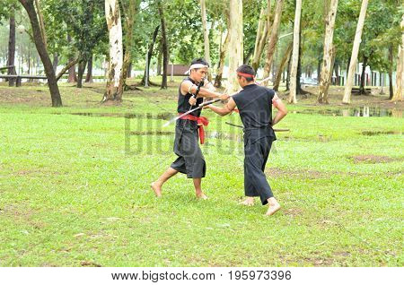PUKED,THAILAND - AUGUST 28: Master trick of ancient fighter on August 28, 2011 in Puked Thailand.
 Master show how to trick of fight with swords.