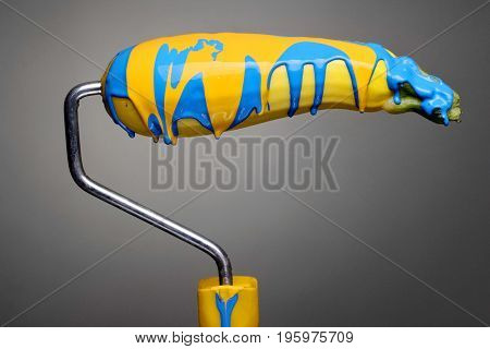 Paint Roller Zucchini With Pouring Sky Blue And Yellow Paint On Gray Background. Fashion Food Concep