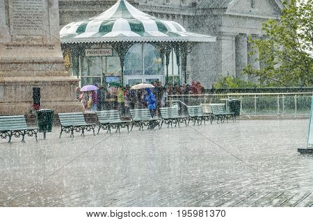 Quebec City Canada - July 27 2014: Crowd of people walking in heavy rain on Dufferin terrace boardwalk street close to Chateau Frontenac