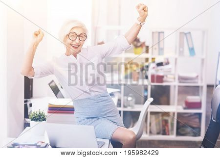 Enjoy new day. Inspiring charismatic mature businesswoman having a lot of plans for today and being excited while spending the morning at the office