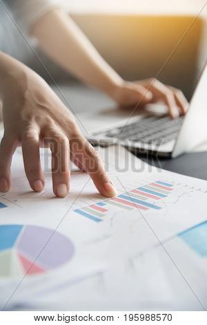 Close up of Business woman hands on Graph financial diagram documents.