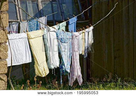 Clothing and linen dries after washing in the yard on a sunny day