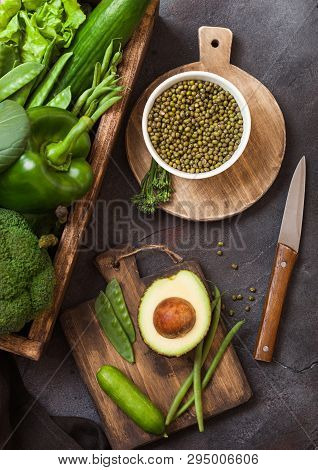 Assorted Green Toned Raw Organic Vegetables In Wooden Box On Dark Stone Background. Avocado, Cabbage