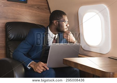 Attractive And Successful African American Businessman With Glasses Working On A Laptop While Sittin