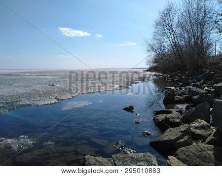 Melted Ice On The Shore Of The Lake In The Spring On A Sunny Clear Day