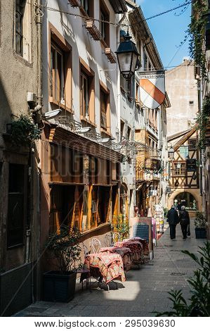 Strasbourg, France - Apr 19, 2016: Senior Couple On Cute Street Tiny Vintage Timbered Houses Buildin